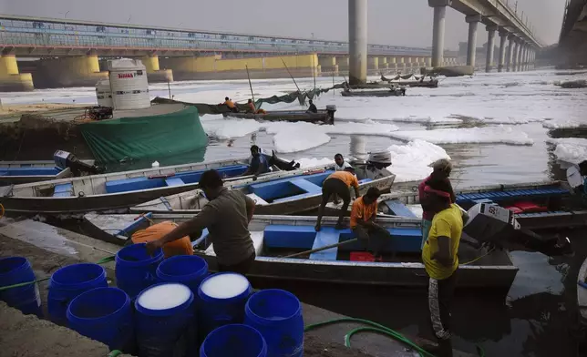 Workers for the Delhi Jal or water board gets ready to clean the toxic foams in the river Yamuna in New Delhi, India, Tuesday, Oct. 29, 2024. (AP Photo/Manish Swarup)