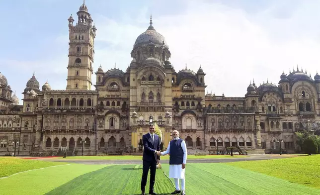 In this photo provided by the Gujarat state Press Information Bureau, Indian Prime Minister Narendra Modi, right, shakes hand with his Spanish counterpart Pedro Sanchez in front of Laxmi Vilas Palace before their meeting in Vadodara, India, Monday, Oct. 28, 2024. (Gujarat State Press Information Bureau via AP)