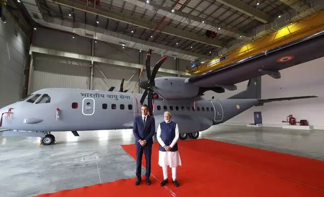 In this photo provided by the Gujarat state Press Information Bureau, Indian Prime Minister Narendra Modi and his Spanish counterpart Pedro Sanchez, pose in front of C-295 transport military aircraft after inaugurating India's first private military aircraft plant in Vadodara, India, Monday, Oct. 28, 2024. (Gujarat State Press Information Bureau via AP)