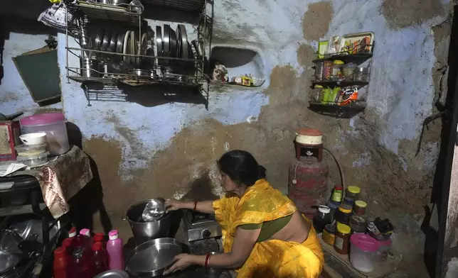 A woman works in her kitchen with steel utensils made by Tata inside her house in Prayagraj, India, Thursday, Oct. 10, 2024. (AP Photo/Rajesh Kumar Singh)