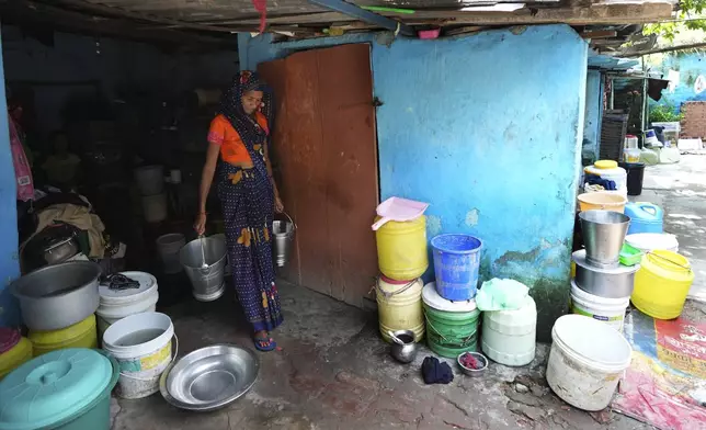 A woman carries Tata steel buckets for filling water in a shanty area, in Prayagraj, India, Thursday, Oct. 10, 2024. (AP Photo/Rajesh Kumar Singh)