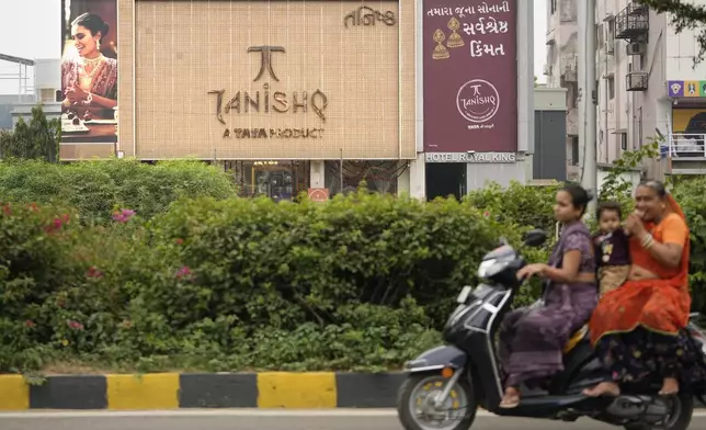 Motorists ride past a Tanishq jewelry store, a Tata group venture, in Ahmedabad, India, Thursday, Oct. 10, 2024. (AP Photo/Ajit Solanki)