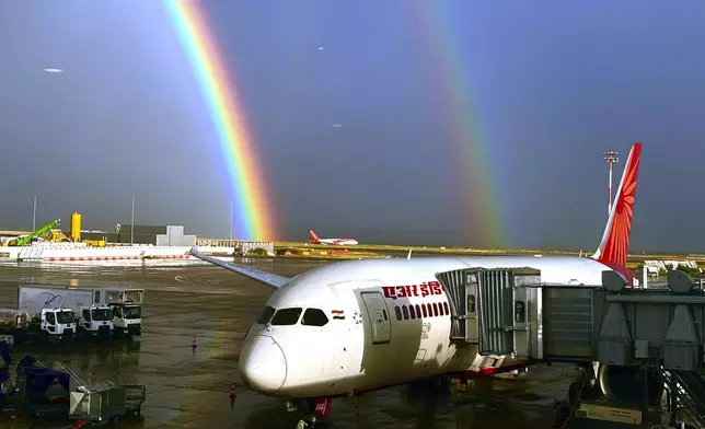 An Air India aircraft, owned by the Tata Group, is seen parked against a double rainbow formed over Charles de Gaulle Airport in Paris, France, Friday, Aug. 9, 2024. (AP Photo/Manish Swarup)