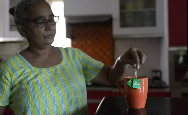 Rita, 52, makes tea using Tata tea bags in New Delhi,India, Thursday, Oct. 10, 2024. (AP Photo/Manish Swarup)