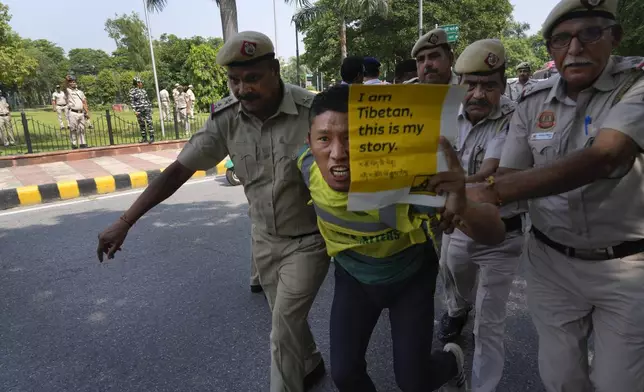 Policemen detain an exile Tibetan protesting against the human rights situation in Tibet during a protest to coincide China marking its 75th year of Communist Party rule, outside Chinese embassy, in New Delhi, India, Tuesday, Oct. 1, 2024. (AP Photo/Manish Swarup)