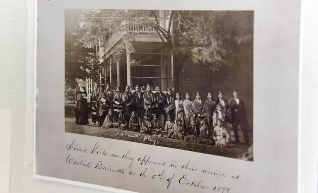 FILE - A poster about the history of Carlisle Indian Reform School includes a historical photo of Sioux girls upon arrival from their homes to the boarding school on Saturday, July 17, 2021 at the Sinte Gleska University Student Multicultural Center in Rosebud, S.D. (Erin Bormett/The Argus Leader via AP, File)