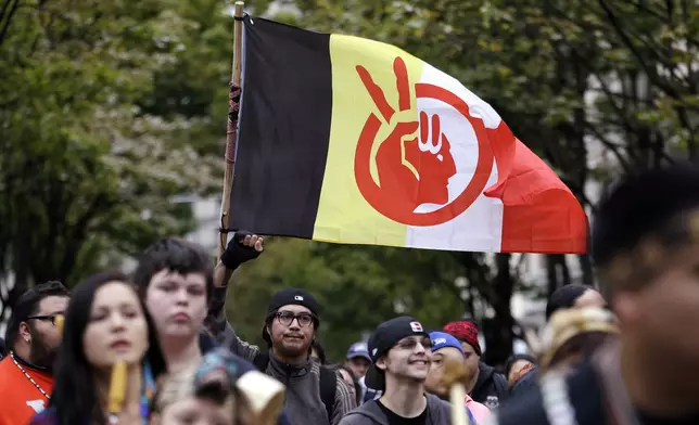 FILE - An American Indian Movement flag is flow during a march for Indigenous Peoples Day, Oct. 12, 2015, in Seattle. (AP Photo/Elaine Thompson, File)