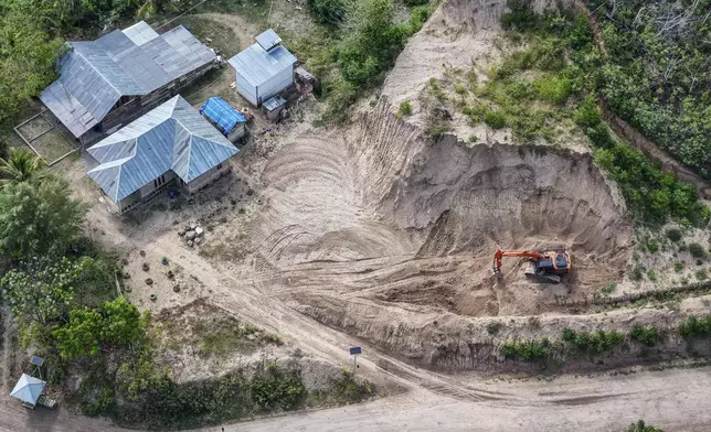 A machine operates near a road leading to the area of wood pellet production companies in Pohuwato, Gorontalo province, Indonesia, Tuesday, Oct. 22, 2024. (AP Photo/Yegar Sahaduta Mangiri)