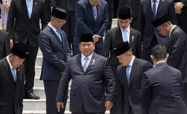 Indonesian President Prabowo Subianto, center, takes his position for a group photo with newly-appointed cabinet ministers after their swearing-in ceremony at Merdeka Palace in Jakarta, Indonesia, Monday, Oct. 21, 2024. (AP Photo/Achmad Ibrahim)