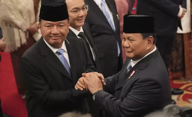 Indonesian President Prabowo Subianto, right, congratulates newly-appointed Coordinating Minister for Political and Security Affairs Budi Gunawan during the swearing-in ceremony of the new cabinet ministers at the presidential palace in Jakarta, Indonesia, Monday, Oct. 21, 2024. (AP Photo/Achmad Ibrahim)