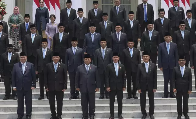 Front row, from left, Indonesia's Coordinating Minister for Economics Airlangga Hartarto, Coordinating Minister for Political and Security Affairs Budi Gunawan, President Prabowo Subianto, Vice President Gibran Rakabuming Raka, Coordinating Minister for Legal, Human Rights, Immigration and Correctional Affairs Yusril Ihza Mahendra, and Coordinating Minister for Human Development and Cultural Affairs Pratikno pose for a group photo with newly-appointed ministers during the swearing-in ceremony of the new cabinet at Merdeka Palace in Jakarta, Indonesia, Monday, Oct. 21, 2024. (AP Photo/Achmad Ibrahim)