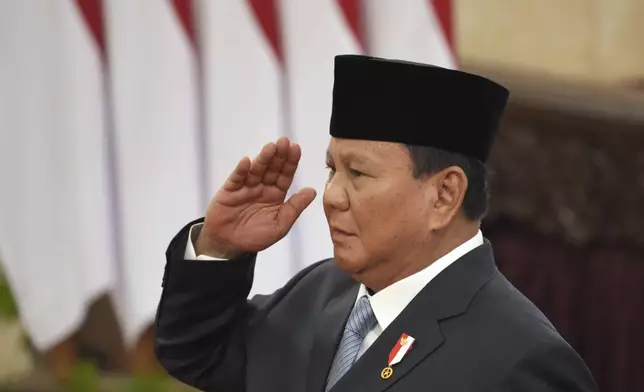 Indonesian President Prabowo Subianto salutes during the swearing-in ceremony of the new cabinet ministers at the presidential palace in Jakarta, Indonesia, Monday, Oct. 21, 2024. (AP Photo/Achmad Ibrahim)