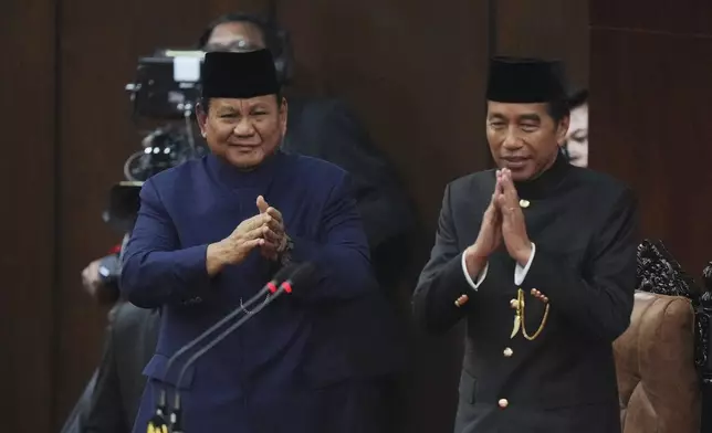 Indonesia's newly-inaugurated Indonesian President Prabowo Subianto, left, and former Indonesian President Joko Widodo salute during the presidential inauguration ceremony at the Parliament building in Jakarta, Indonesia, Sunday, Oct. 20, 2024. (AP Photo/Tatan Syuflana)