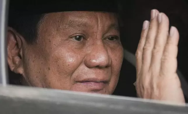 Indonesian president-elect Prabowo Subianto, waves to media as he leave for inauguration ceremony in Jakarta, Indonesia, Sunday, Oct. 20, 2024. (AP Photo/Dita Alangkara)