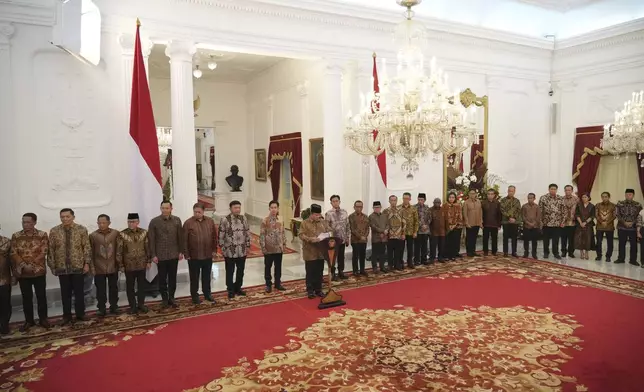 Newly appointed cabinet ministers stand behind Indonesia's new President Prabowo Subianto, center, as he announces his cabinet lineup at Merdeka Palace in Jakarta, Indonesia, Sunday, Oct. 20, 2024. (AP Photo/Achmad Ibrahim)