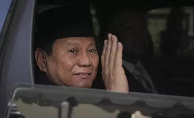 Indonesian president-elect Prabowo Subianto, waves to media as he leave for inauguration ceremony in Jakarta, Indonesia, Sunday, Oct. 20, 2024. (AP Photo/Dita Alangkara)