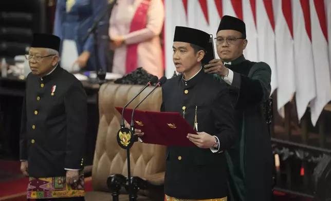 Indonesia's Newly-inaugurated vice president-elect Gibran Rakabuming Raka, who is also the eldest son of outgoing President Joko Widodo, takes the oath during the presidential inauguration ceremony at the Parliament building in Jakarta, Indonesia, Sunday, Oct. 20, 2024. (AP Photo/Tatan Syuflana)