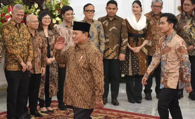 Indonesia's new President Prabowo Subianto, foreground, and Vice President Gibran Rakabuming Raka, right, greet newly-appointed deputy ministers during the announcement of their cabinet lineup at Merdeka Palace in Jakarta, Indonesia, Sunday, Oct. 20, 2024. (AP Photo/Achmad Ibrahim)