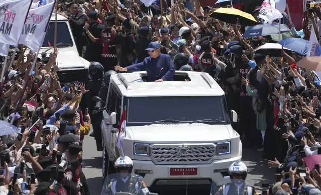 Newly-inaugurated Indonesian President Prabowo Subianto, center, greets supporters after being sworn in as the country's eighth president in Jakarta, Indonesia, Sunday, Oct. 20, 2024. (AP Photo/Dita Alangkara)