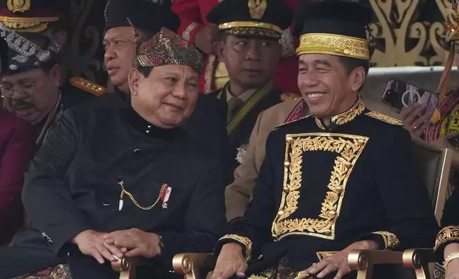 FILE - Defense Minister and president-elect Prabowo Subianto,left, shares a light moment with President Joko Widodo during the ceremony marking Indonesia's 79th anniversary of independence at the new presidential palace in the future capital of Nusantara, a city still under construction on the island of Borneo, Saturday, Aug. 17, 2024. (AP Photo/Achmad Ibrahim, File)