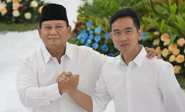 FILE - Indonesian Defense Minister and president-elect Prabowo Subianto, left, shakes hands with his running mate Gibran Rakabuming Raka, the eldest son of Indonesian President JokoWidodo, during their formal declaration as president and vice president-elect at the General Election Commission building in Jakarta, Indonesia, Wednesday, April 24, 2024. (AP Photo/Dita Alangkara, File)