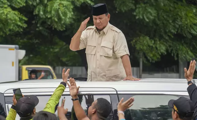 FILE - Indonesian Defense Minister and presidential frontrunner Prabowo Subianto greets supporters after visiting his father's grave in Jakarta, Indonesia Thursday, Feb. 15, 2024. (AP Photo/Tatan Syuflana, File)