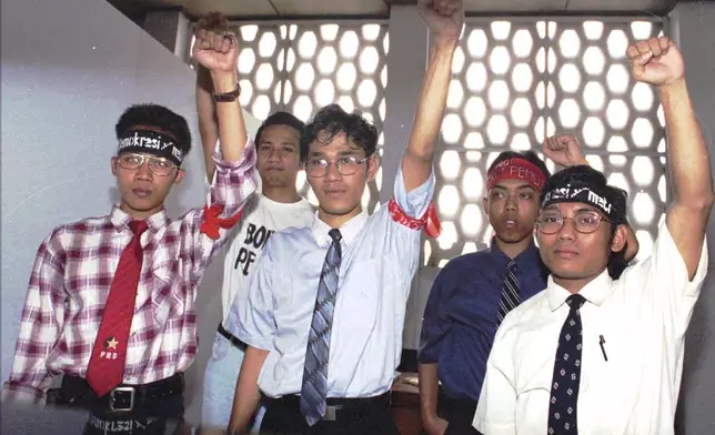 FILE - Five activists of the unrecognized People's Democratic Party, including Budiman Sudjatmiko, center, raise their fists while posing for photographers in front of a room at the Central Jakarta district court Monday, April 28, 1997. (AP Photo/Ujang, File)