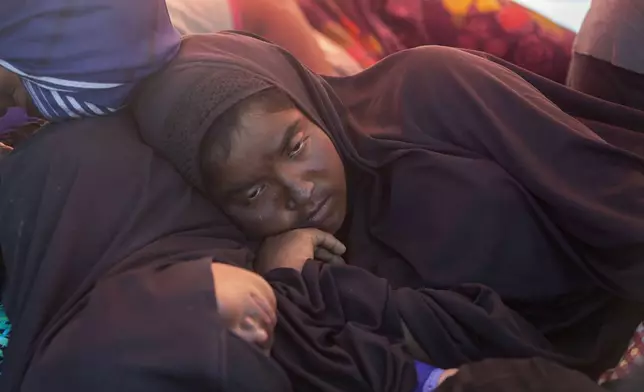 A Rohingya woman rests on the deck of a boat carrying refugees anchored in the waters near the coast of Labuhan Haji, Aceh province, Indonesia, Tuesday, Oct. 22, 2024. (AP Photo/Binsar Bakkara)