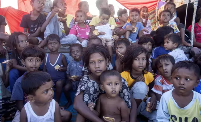 Rohingya refugee children sit on the deck of their boat anchored in the waters near the coast of Labuhan Haji, Aceh province, Indonesia, Tuesday, Oct. 22, 2024. (AP Photo/Binsar Bakkara)