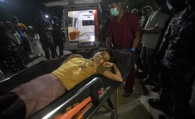 A young girl who was evacuated from a boat carrying Rohingya Muslims lies on a stretcher as she is taken to a local hospital to check on her medical condition in Labuhan Haji, Aceh province, Indonesia, Tuesday, Oct. 22, 2024. (AP Photo/Binsar Bakkara)