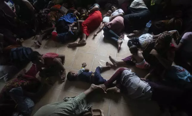 Newly arrived Rohingya Muslims rest on the floor at a temporary shelter in Pantai Labu, North Sumatra, Indonesia, Friday, Oct. 25, 2024. (AP Photo/Binsar Bakkara)