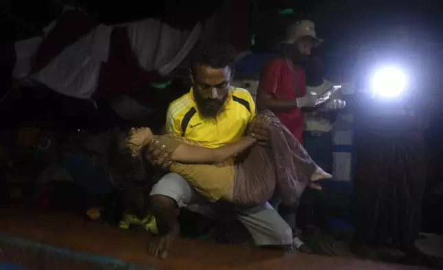 A young girl is evacuated from the boat carrying Rohingya Muslims due to her medical condition, in the waters near the coast of Labuhan Haji, Aceh province, Indonesia, Tuesday, Oct. 22, 2024. (AP Photo/Binsar Bakkara)