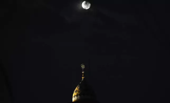 The moon rises seen from Jakarta, Indonesia, Thursday, Oct.17, 2024 .(AP Photo/Achmad Ibrahim)