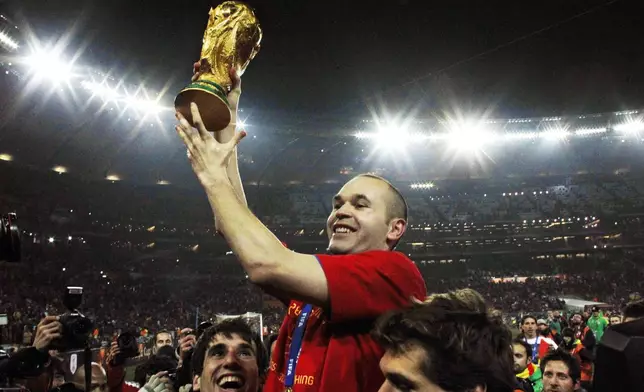 FILE - Spain's Andres Iniesta holds up the World Cup trophy after the World Cup final soccer match between the Netherlands and Spain at Soccer City in Johannesburg, South Africa, July 11, 2010. Andres Iniesta who scored Spain's World Cup-winning goal in 2010 and was one of the key players who made Barcelona's tiki-taka thrive for so long, announced his retirement from soccer on Tuesday. (AP Photo/Bernat Armangue, File)