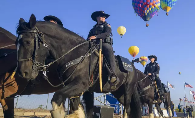 The Albuquerque Police Department's (APD) Horse Mounted Unit patrols during the 52nd Albuquerque International Balloon Fiesta in Albuquerque, N.M., on Saturday, Oct. 5, 2024. (AP Photo/Roberto E. Rosales)