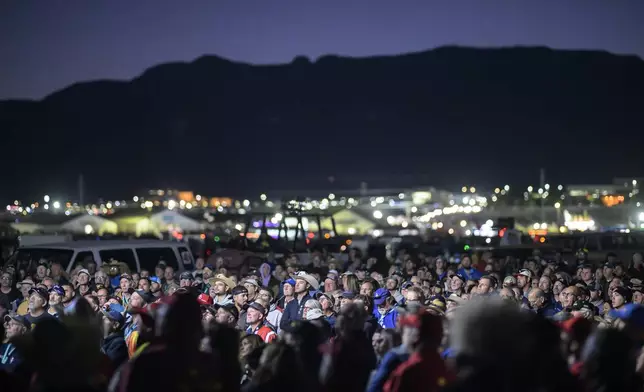 Pilots gather for a briefing just before sunrise prior to the start of the 52nd Albuquerque International Balloon Fiesta in Albuquerque, N.M., on Saturday, Oct. 5, 2024. (AP Photo/Roberto E. Rosales)