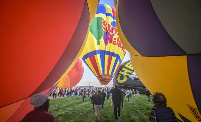 Spectators watch as hot air balloons take off during the mass ascension at the 52nd Albuquerque International Balloon Fiesta in Albuquerque, N.M., on Saturday, Oct. 5, 2024. (AP Photo/Roberto E. Rosales)