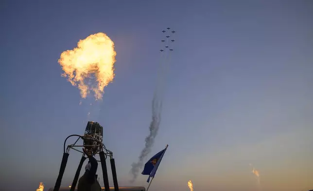 A fly-over by The Chili Flight Team, and a candlelight burn by balloon teams followed the national anthem during he 52nd Albuquerque International Balloon Fiesta in Albuquerque, N.M., on Saturday, Oct. 5, 2024. (AP Photo/Roberto E. Rosales)