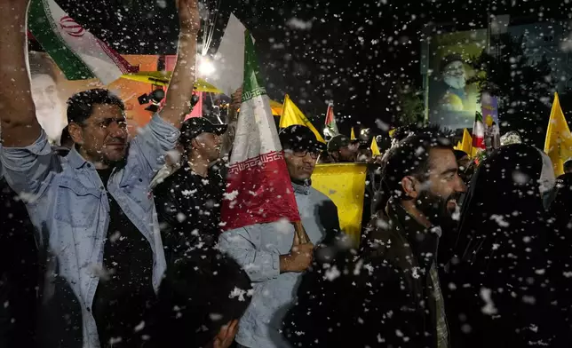 Demonstrators cheer as artificial snow sprayed in an anti-Israeli gathering celebrating Iran's missile strike against Israel, at Felestin (Palestine) Sq. in Tehran, Iran, Tuesday, Oct. 1, 2024. (AP Photo/Vahid Salemi)