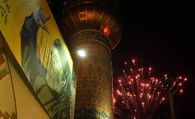 Fireworks explode next a portrait of slain Hezbollah leader Hassan Nasrallah and a minaret of a mosque in an anti-Israeli gathering celebrating Iran's missile strike against Israel, at Felestin (Palestine) Sq. in Tehran, Iran, Tuesday, Oct. 1, 2024. (AP Photo/Vahid Salemi)