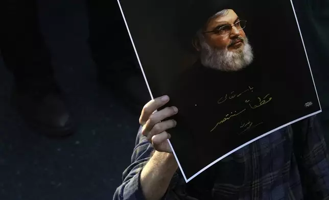 A mourner holds up a poster of slain Hezbollah leader Hassan Nasrallah with a quotation of him: "We will definitely win" at Enqelab-e-Eslami (Islamic Revolution) St. in downtown Tehran, Iran, Monday, Sept. 30, 2024. (AP Photo/Vahid Salemi)