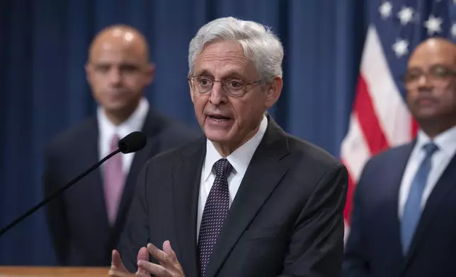 FILE - Attorney General Merrick Garland, flanked by Matt Graves, U.S. attorney for the District of Columbia, left, and Ronald Davis, director of the U.S. Marshals Service, holds a news conference as the Justice Department announced criminal charges against Iranian operatives suspected of hacking Donald Trump's presidential campaign and disseminating stolen information to media organizations, at the Justice Department in Washington, Sept. 27, 2024. (AP Photo/J. Scott Applewhite, File)