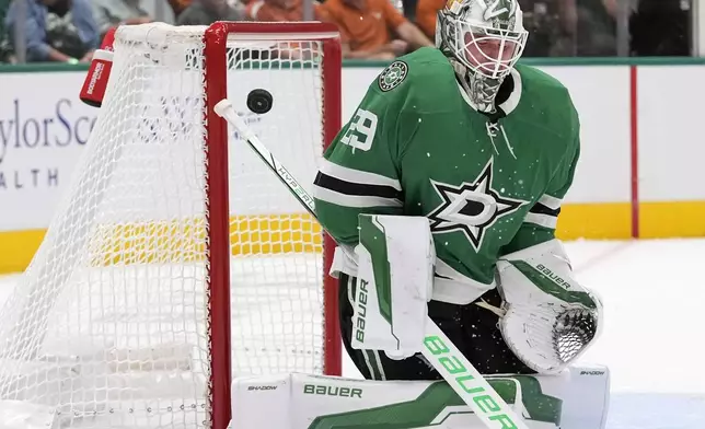 Dallas Stars goaltender Jake Oettinger (29) deflects a shot on goal during the second period of an NHL hockey game against the New York Islanders, Saturday, Oct. 12, 2024, in Dallas. (AP Photo/LM Otero)