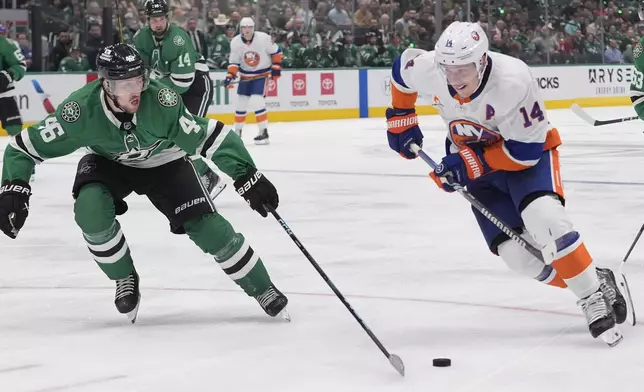 New York Islanders center Bo Horvat (14) and Dallas Stars defenseman Ilya Lyubushkin (46) skate for the puck during the second period of an NHL hockey game Saturday, Oct. 12, 2024, in Dallas. (AP Photo/LM Otero)