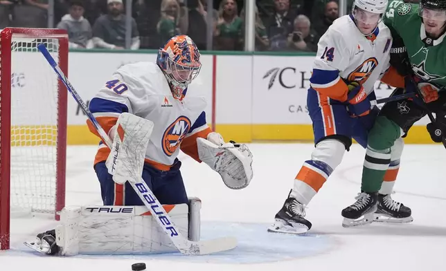 New York Islanders goaltender Semyon Varlamov (40) and center Bo Horvat (14) defend the goal against Dallas Stars center Roope Hintz (24) during the first period of an an NHL hockey game, Saturday, Oct. 12, 2024, in Dallas. (AP Photo/LM Otero)