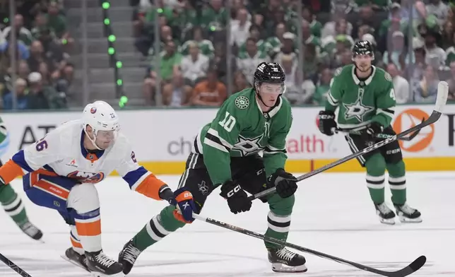 Dallas Stars center Oskar Bäck (10) and New York Islanders right wing Oliver Wahlstrom (26) skate for the puck during the first period of an an NHL hockey game Saturday, Oct. 12, 2024, in Dallas. (AP Photo/LM Otero)