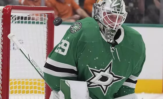 Dallas Stars goaltender Jake Oettinger (29) deflects a shot on goal during the second period of an NHL hockey game against the New York Islanders, Saturday, Oct. 12, 2024, in Dallas. (AP Photo/LM Otero)