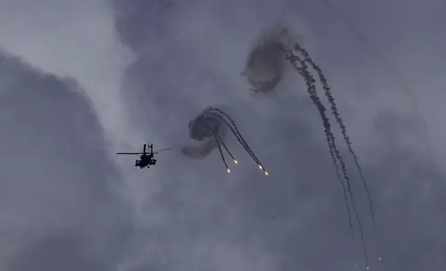 An Israeli Apache helicopter releases flares near the Israeli-Lebanon border, as seen from northern Israel, Wednesday, Oct. 2, 2024. (AP Photo/Baz Ratner)