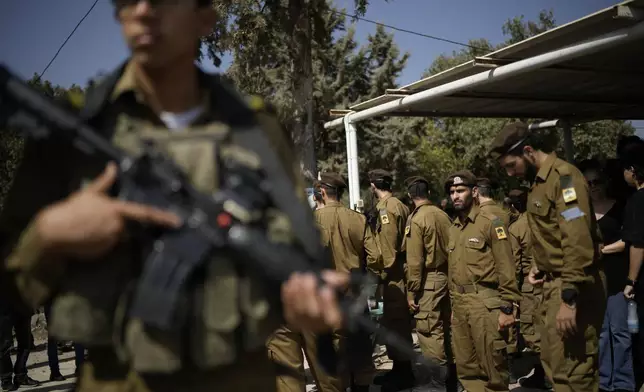 Israeli soldiers mourn Sgt. Yosef Hieb, killed Sunday by a Hezbollah drone attack that wounded dozens and killed four soldiers, while at his funeral in Tuba Zangariyye, Israel, Monday, Oct. 14, 2024. (AP Photo/Leo Correa)