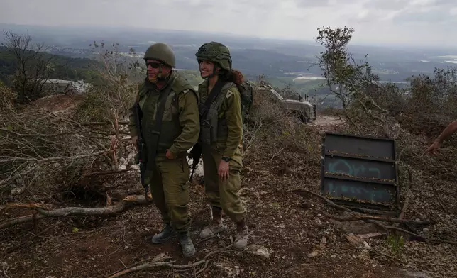 Israeli soldiers display what they say is an entrance to a Hezbollah tunnel found during their ground operation in southern Lebanon, near the border with Israel, Sunday, Oct. 13, 2024. (AP Photo/Sam McNeil)